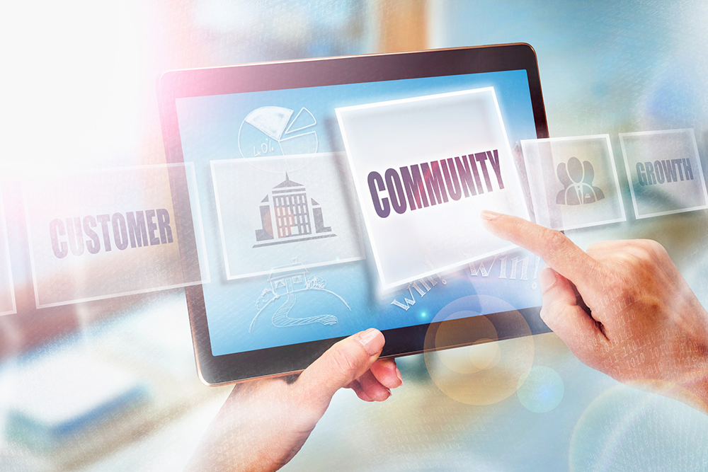 The word "community" on an ipad screen with someone clicking on it